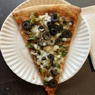 Specialty Slice with mushrooms, black olives, green peppers, and spinach