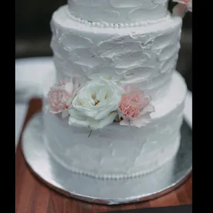 Textured buttercream. Didn't melt at all! We added our own flowers after delivery to save money.