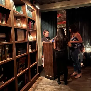 a group of people standing in front of a bookshelf