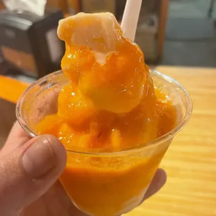 a hand holding a cup of peaches