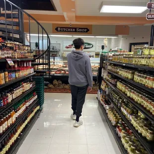 a man walking down the aisle of a grocery store