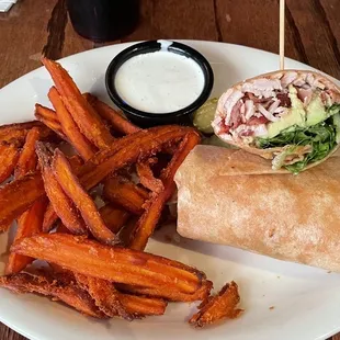 Turkey, bacon, and avocado wrap with sweet potato fries