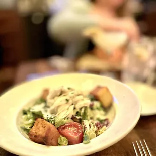 a plate of salad on a wooden table