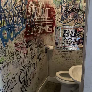 a bathroom with graffiti on the walls