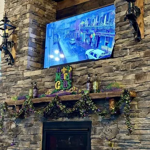 a tv mounted on a stone fireplace