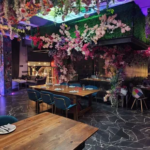 a dining room with flowers hanging from the ceiling
