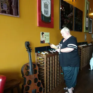 a woman standing in front of a wine rack