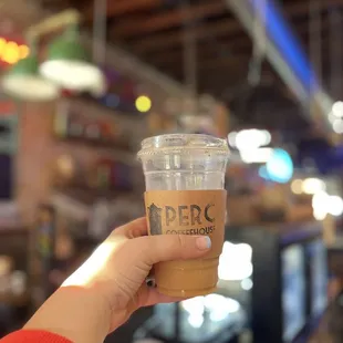 a hand holding a cup of coffee