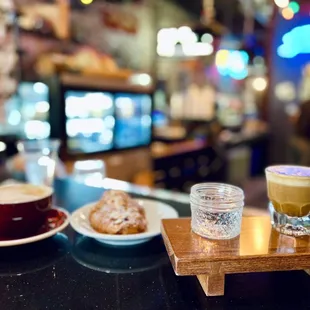 two cups of coffee and a pastry