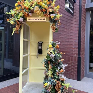 a phone booth decorated with flowers