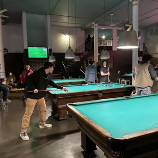 people playing pool in a large room