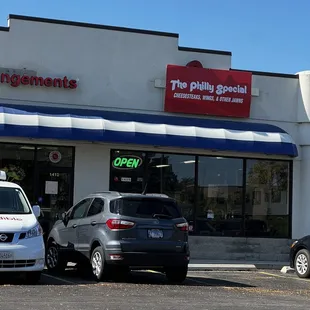 two cars parked in front of a restaurant