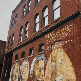 a brick building with a mural on it