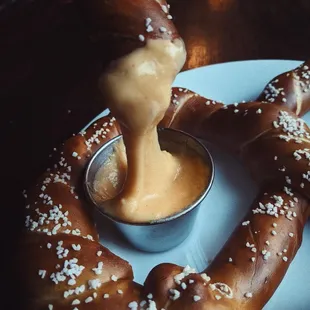 A staple from our menu, the pretzel served with beer cheese and sweet honey mustard sauce.