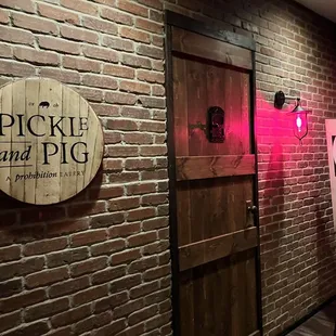 a brick wall with a wooden sign