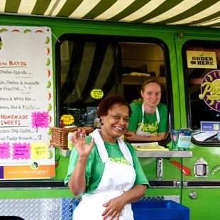 a woman standing in front of a food truck