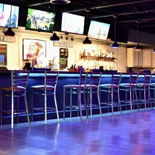 a row of bar stools in a sports bar