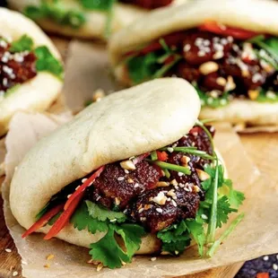 a close up of a bun with meat and vegetables