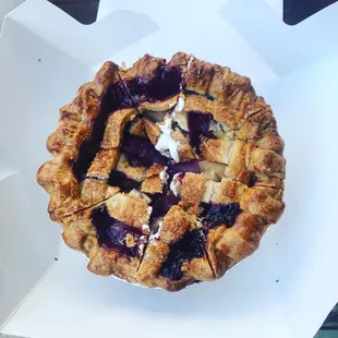 a blueberry pie in a white box