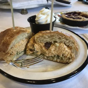 Chicken salad on croissant with a fruit cup.