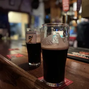 two glasses of beer on a bar