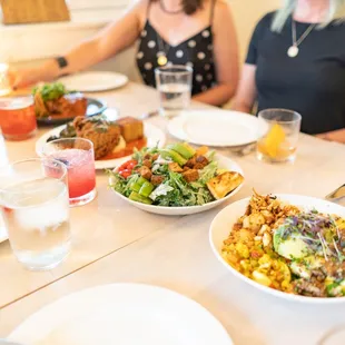 Dinner spread with a Grain Bowl, salad, fried chicken and steak,