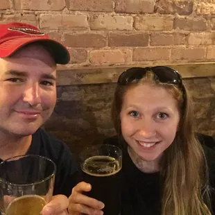 a man and a woman holding glasses of beer