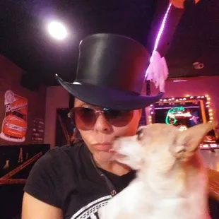 a woman wearing a top hat and holding a dog