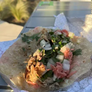 a taco and a drink on a table