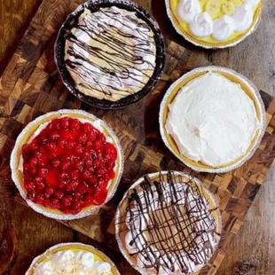 a variety of pies on a wooden table
