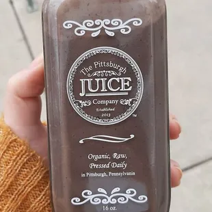 a person holding a bottle of juice