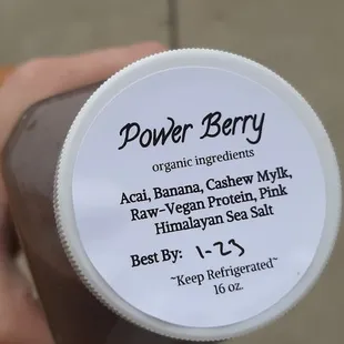 a hand holding a jar of power berry
