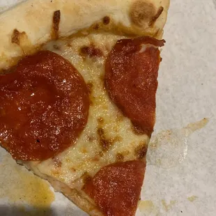 Large slices of pepperoni but large areas not covered by pepperoni too.