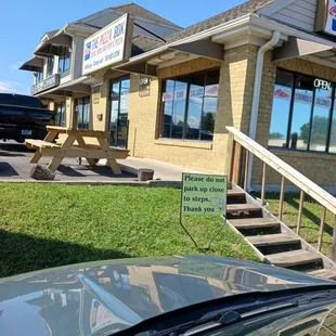 Streetside, the smoker(sorry, not visible), is to the left closer to traffic. The pawn shop is attached, left of the business sign.