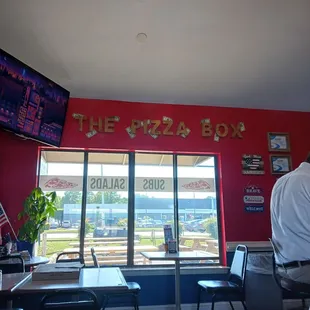 Gold letters say The Pizza Box, you can faintly see the smoker in the background.