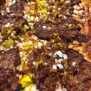 a square pizza with meat and onions
