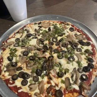 A medium mushroom black olive and green pepper pizza