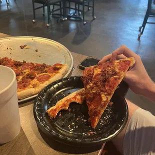 Slice of a large pepperoni and bacon pizza