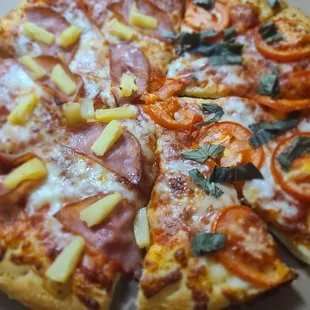a pizza with pineapples and tomatoes