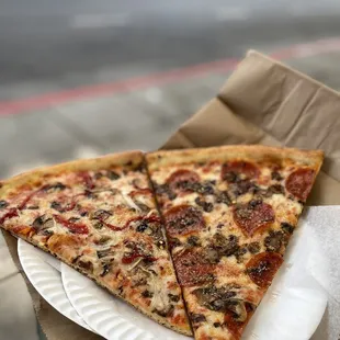 two slices of pizza on a paper plate