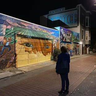 a woman standing in front of a mural
