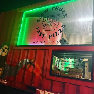 a pizza truck with neon lights