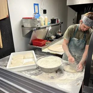 Staff preparing pizza dough