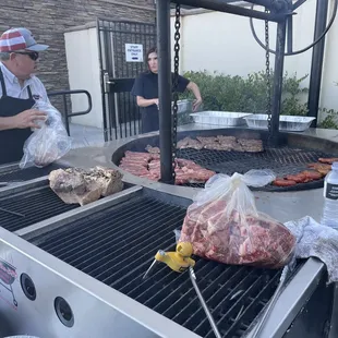 a man cooking meat on a grill