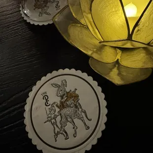 a lit candle and coasters