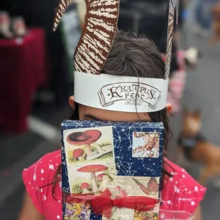 a little girl wearing a paper hat