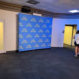 a woman standing in front of a backdrop