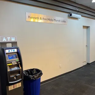 an atm machine and trash can