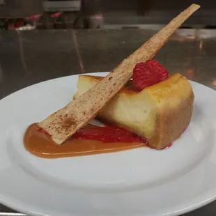 Amazing cheesecake with carmel sauce and raspberry.