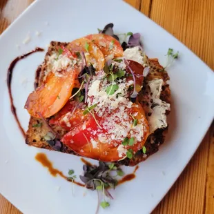 Cheesy polenta, croft farms&apos; heirloom tomatoes, pickled dragon tongue beans, parmesan, herbs.